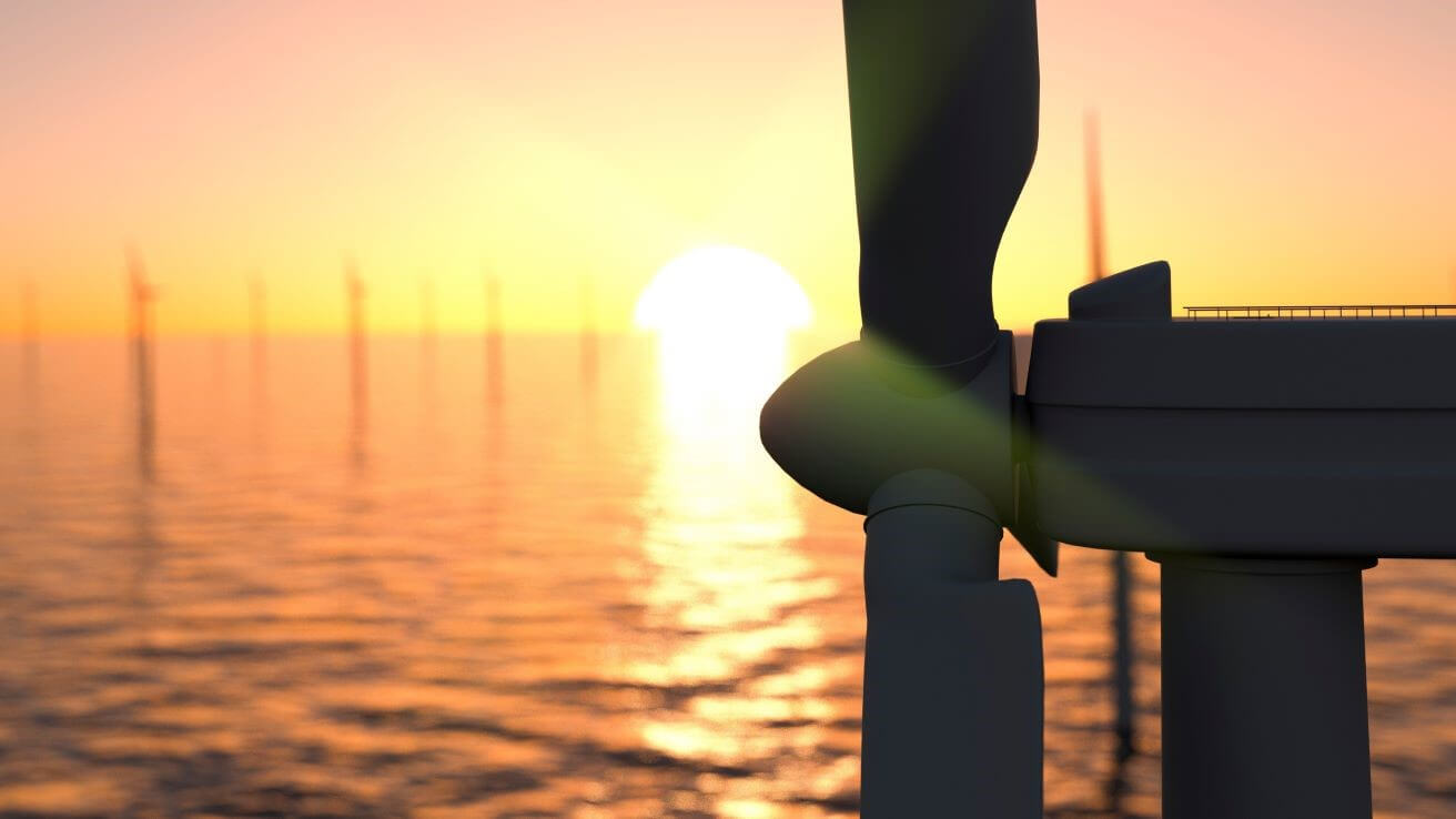Close up of one offshore wind turbine at sunset, others in background
