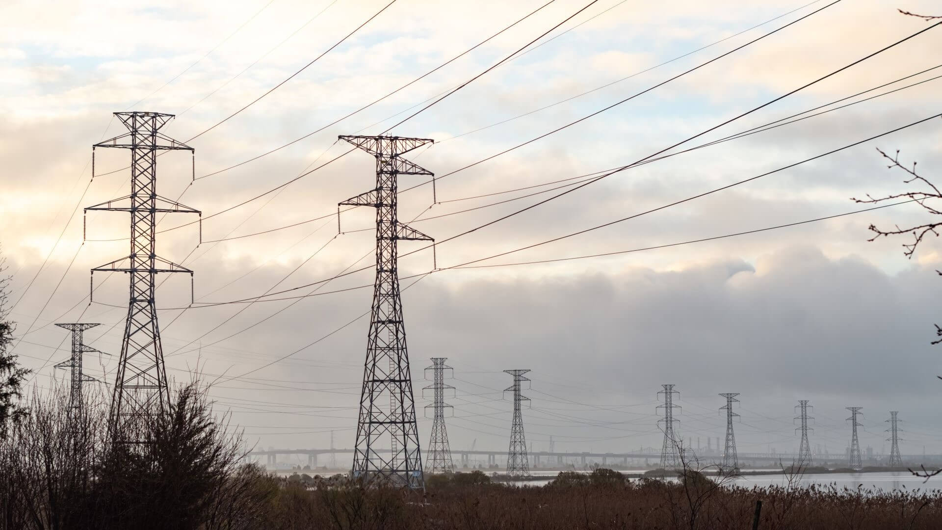 Group of electricity pylons against a grey sky