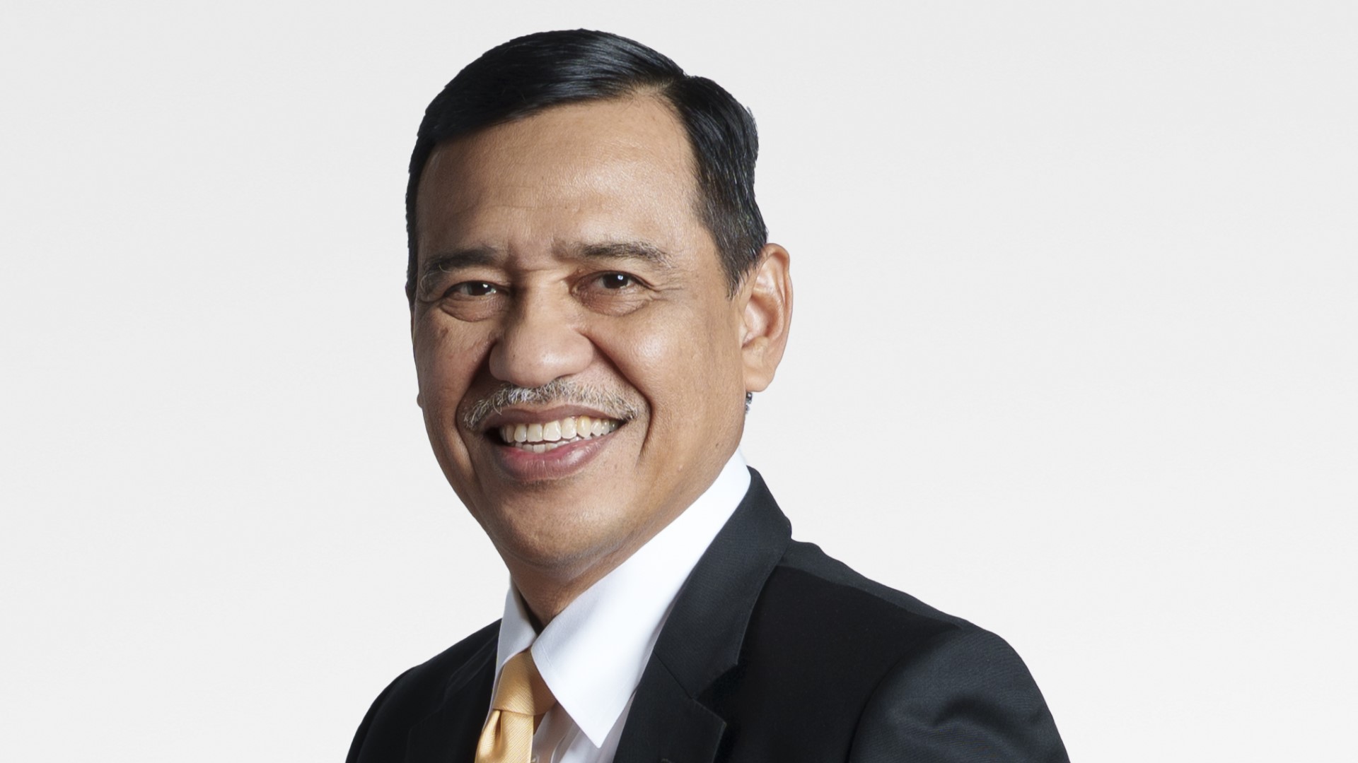 Head and shoulders photo of Ir Mohd Yusri Mohamed Yusof set against buff coloured background