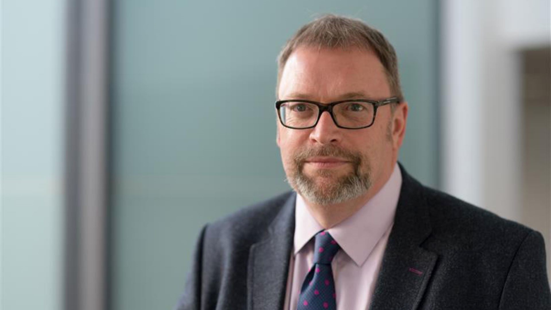 Head and shoulders photo of Michael Bradshaw, with blurred wall and doorway behind