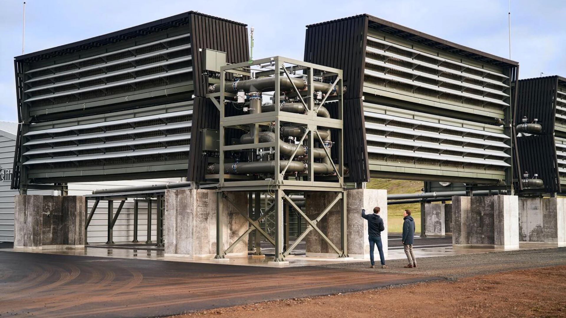 Two people outside Climeworks’ Orca direct air capture and storage plant 