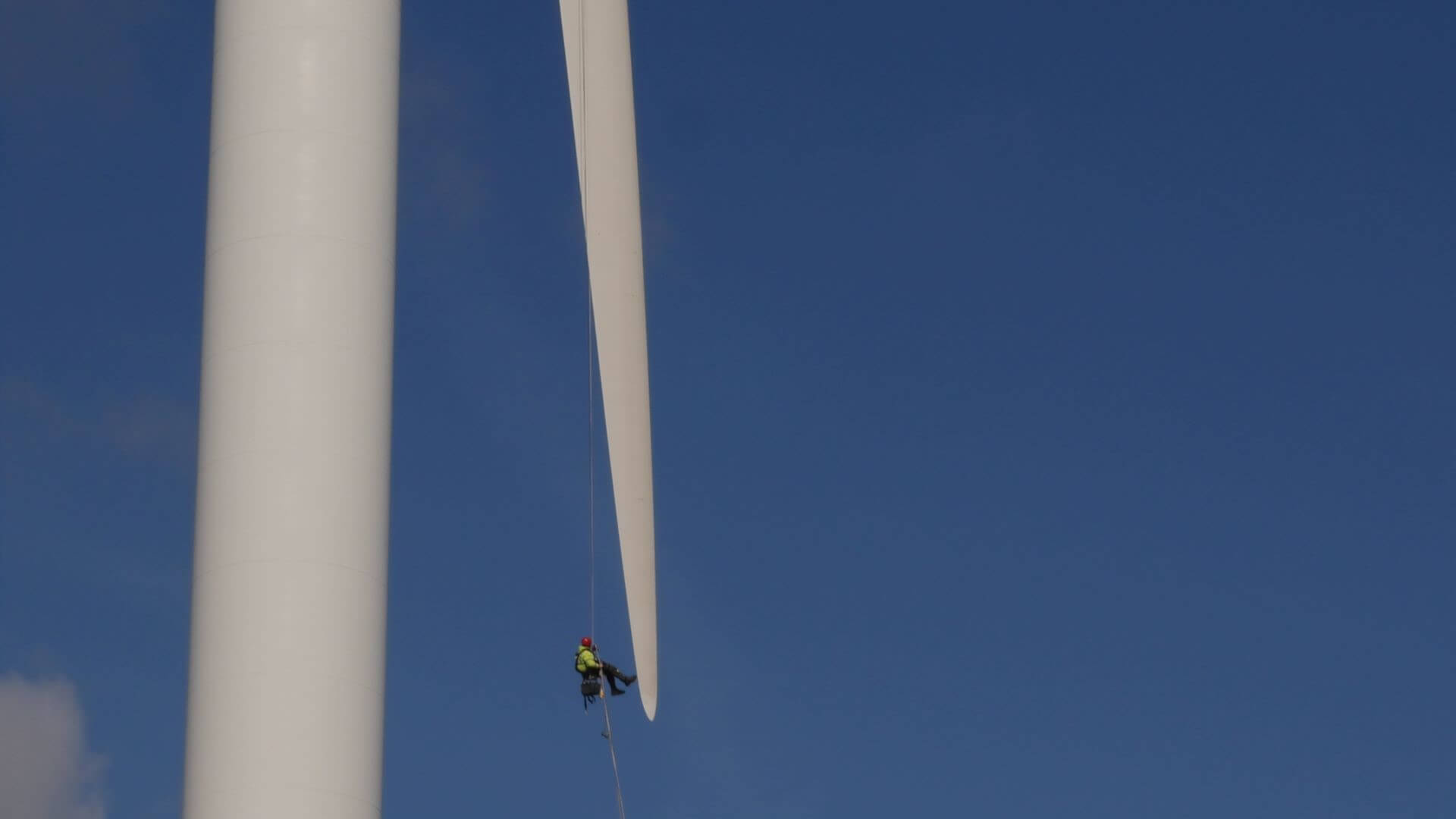Engineer abseiling down wind turbine blade
