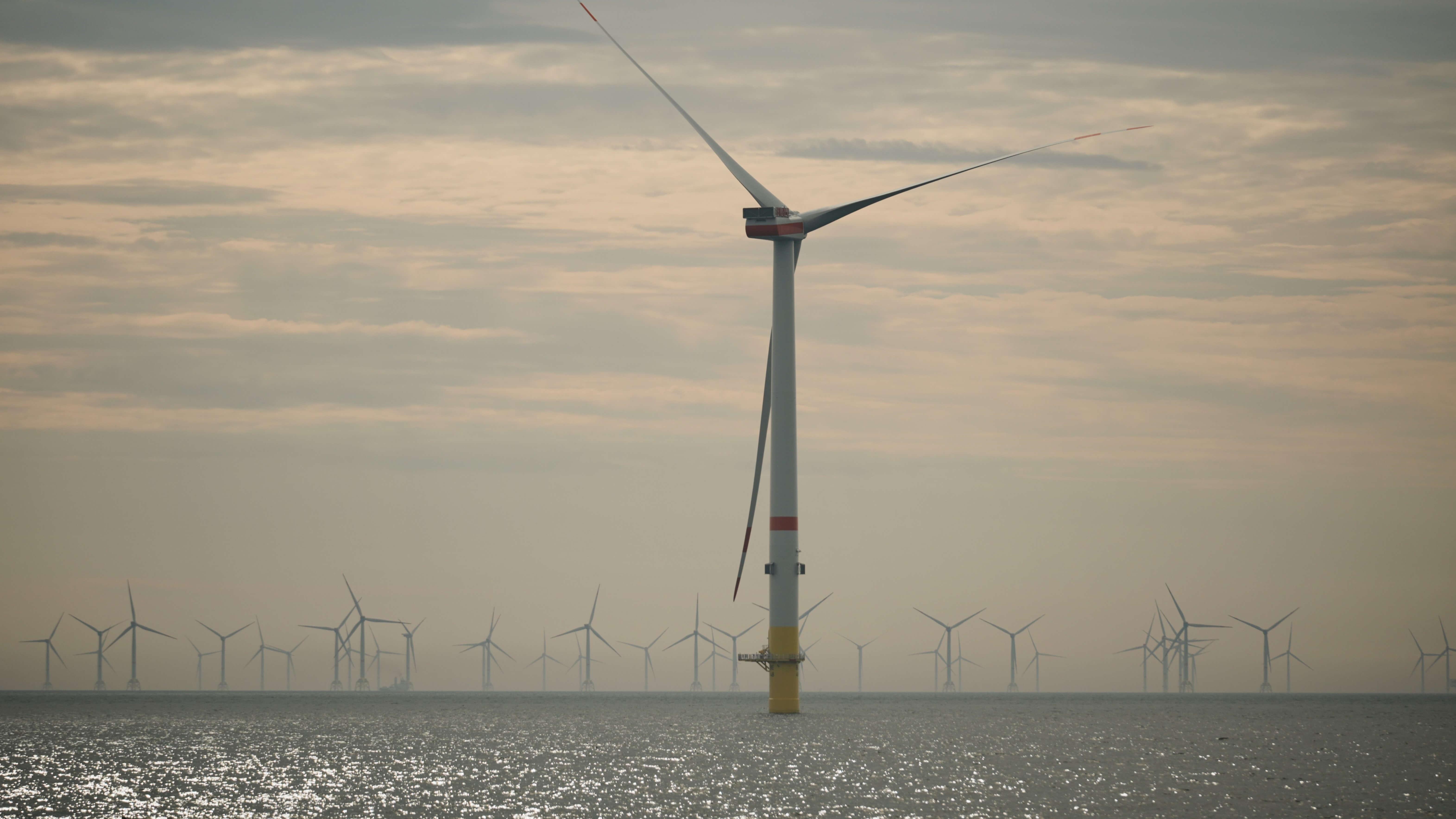 Close up of one offshore wind turbine with others behind