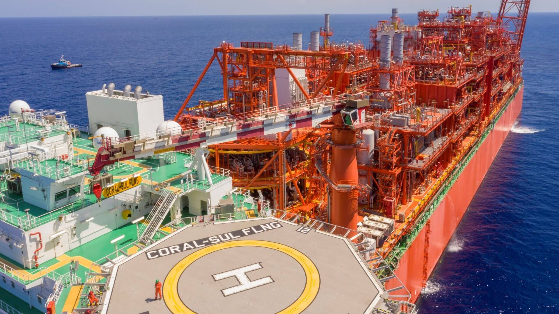 Close aerial view over floating LNG project, showing vessel helipad in foreground and pipework and equipment on vessel running into distance