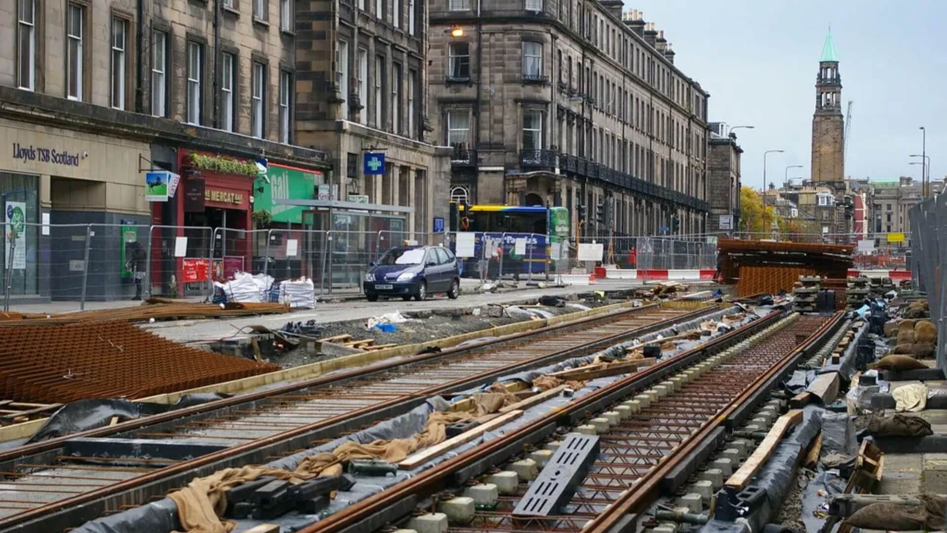 View along tram lines under construction, with city buildings along the lines on the left hand side of the picture