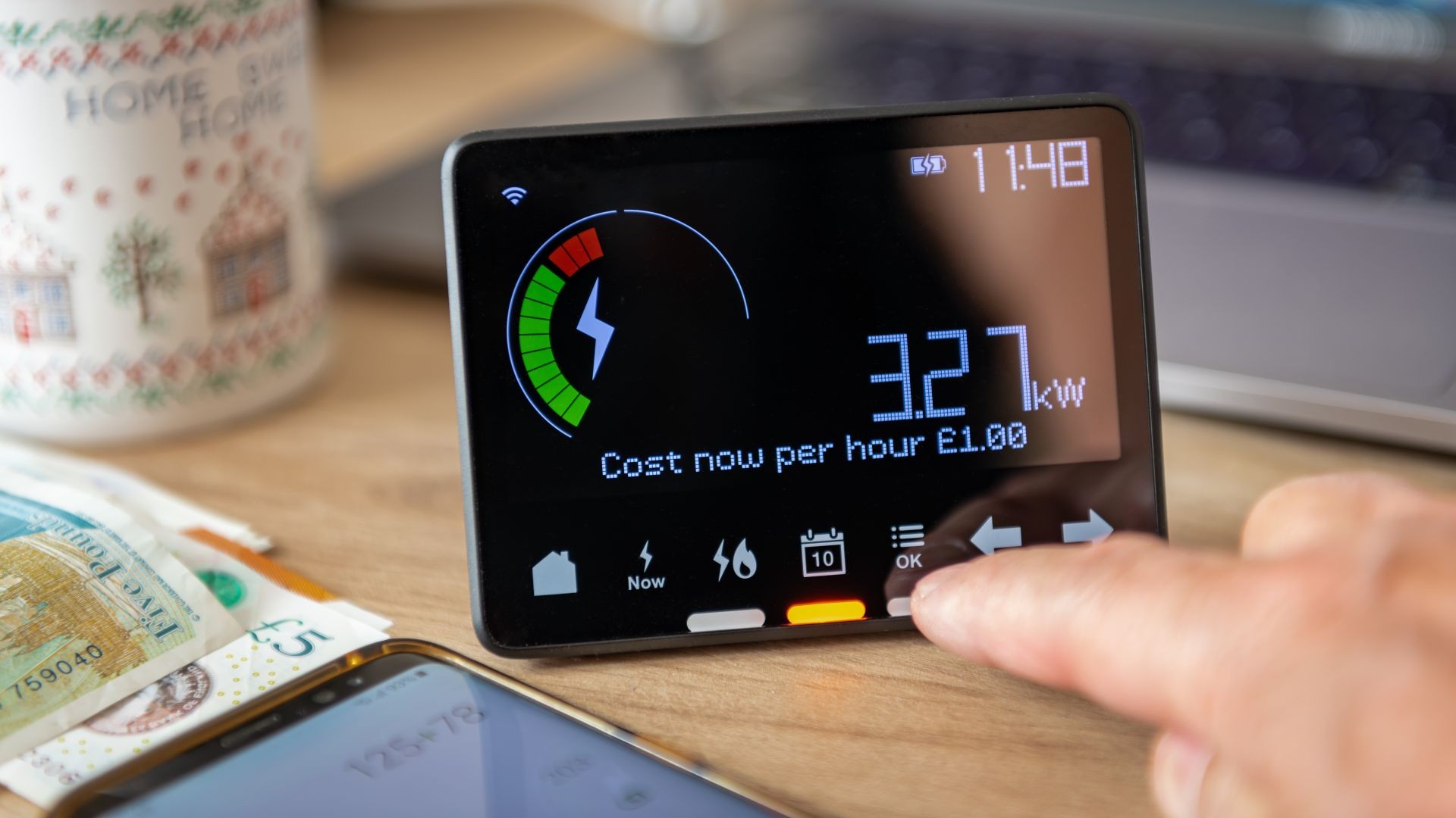 Close up of smart meter display with index finger of a hand pressing one of the operating buttons
