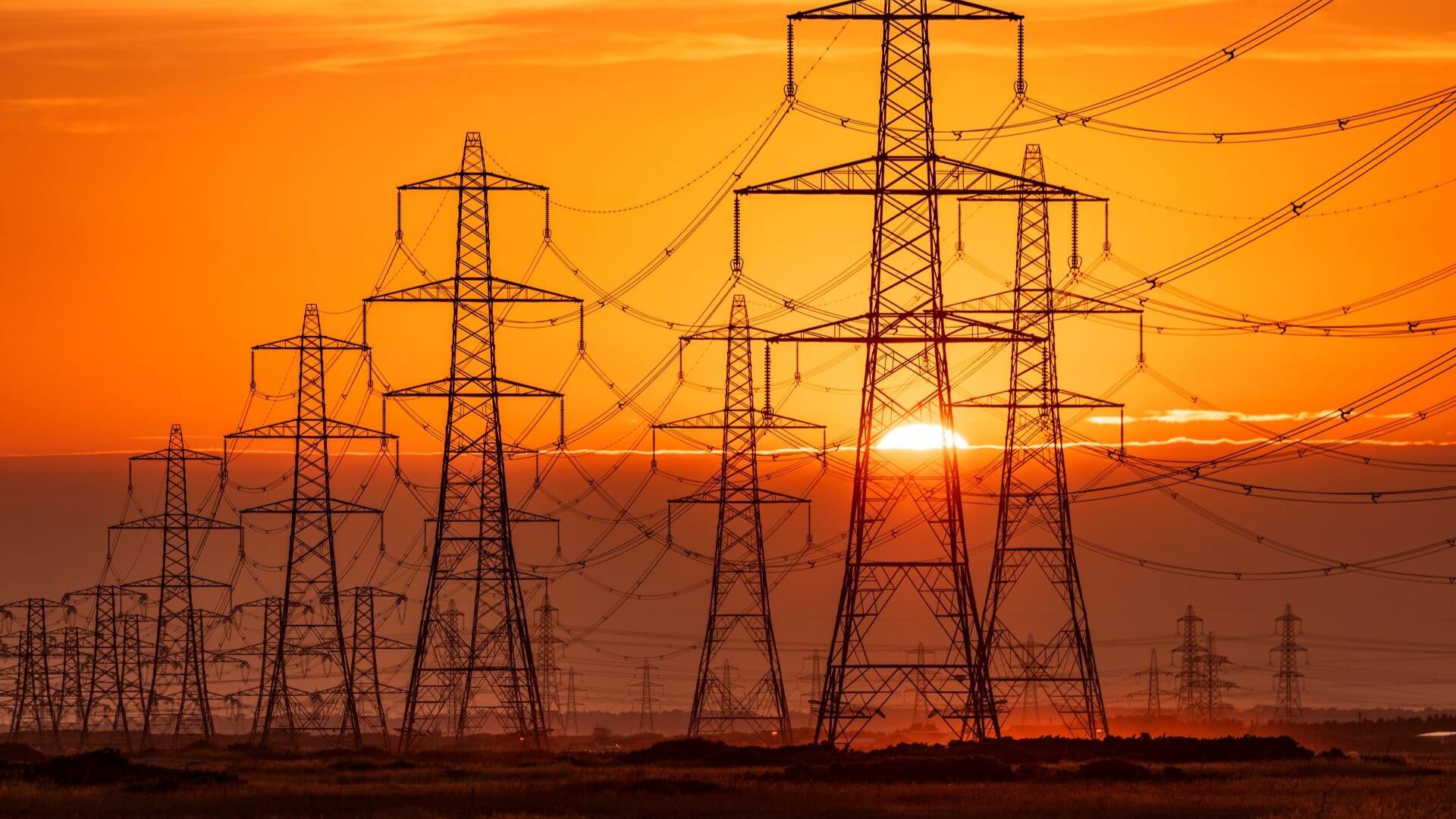 Group of electricity pylons at sunset