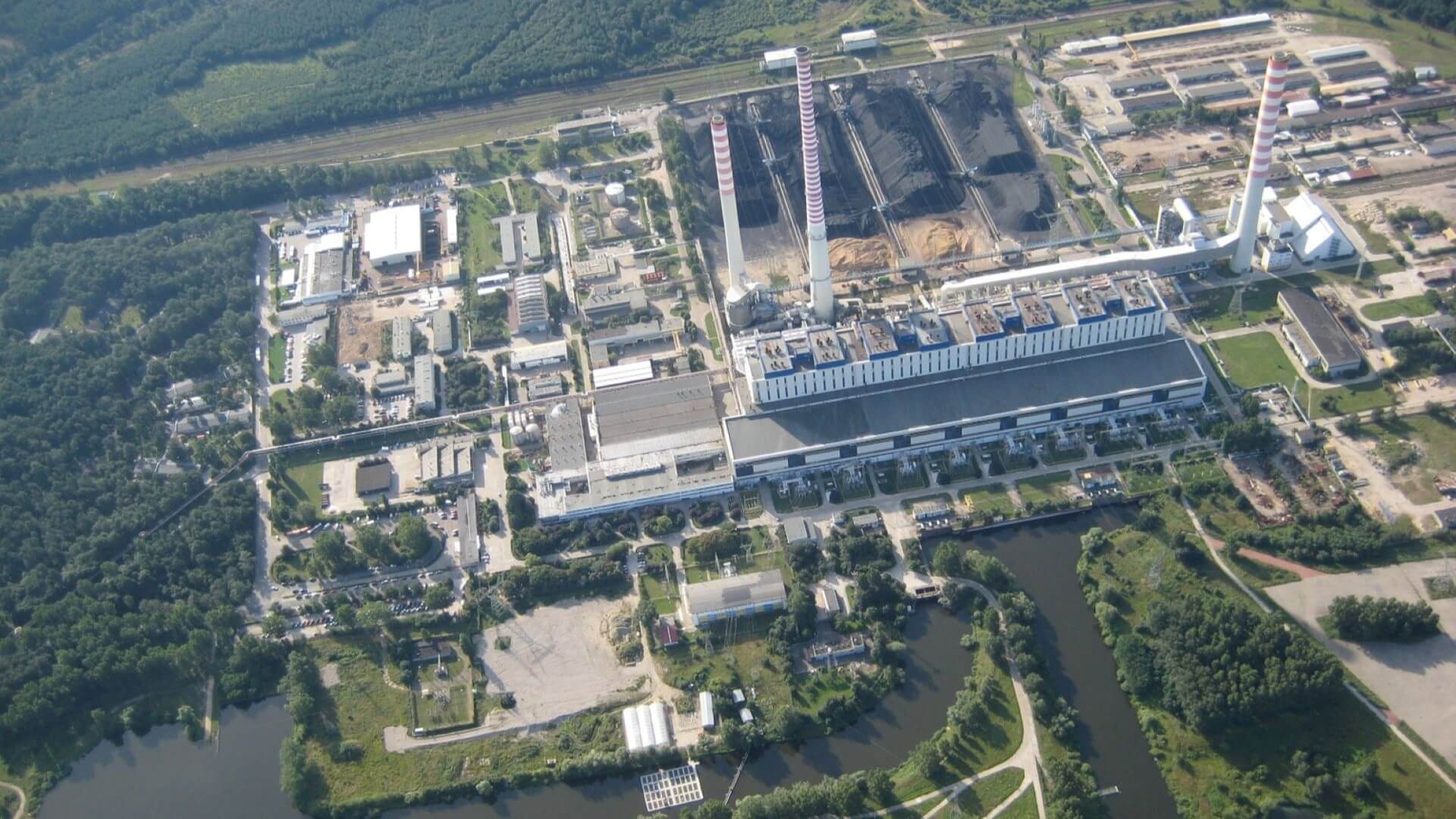 Aerial overview of coal plant showing tall thin chimneys and rectangular industrial buildings