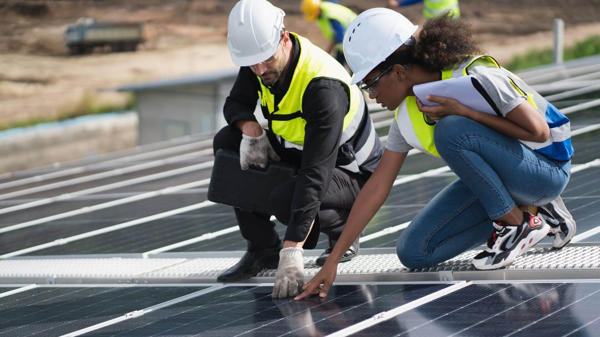 A man and a woman inspecting solar panels