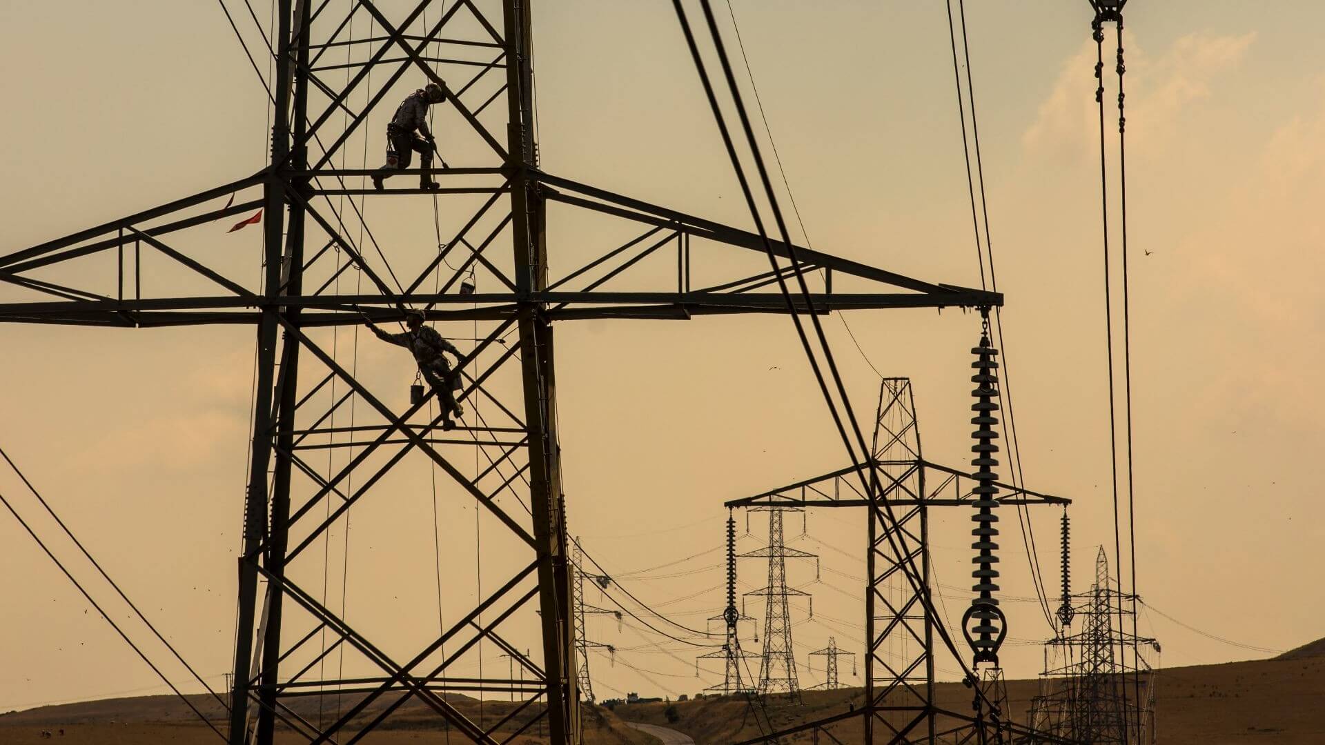 Two engineers working on an electricity pylon