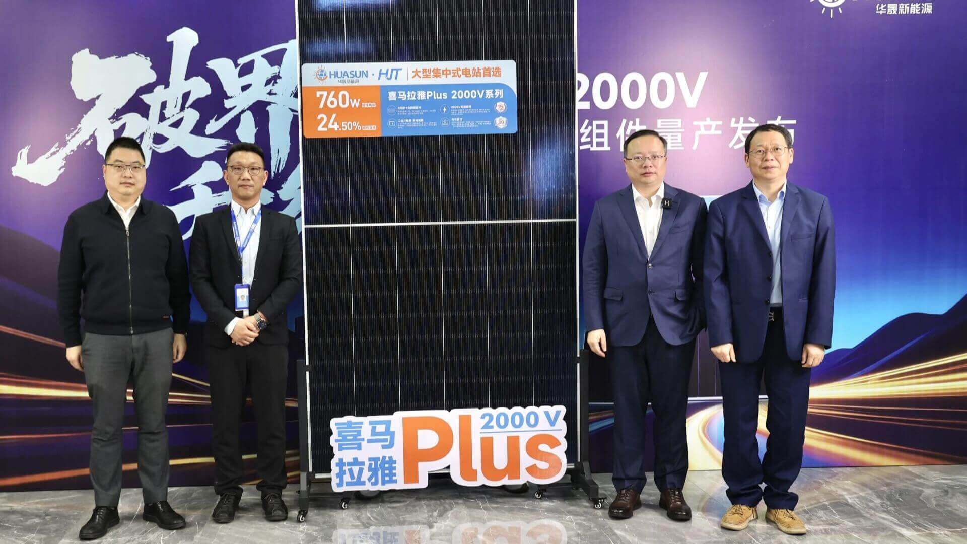 Four men standing with a large solar panel