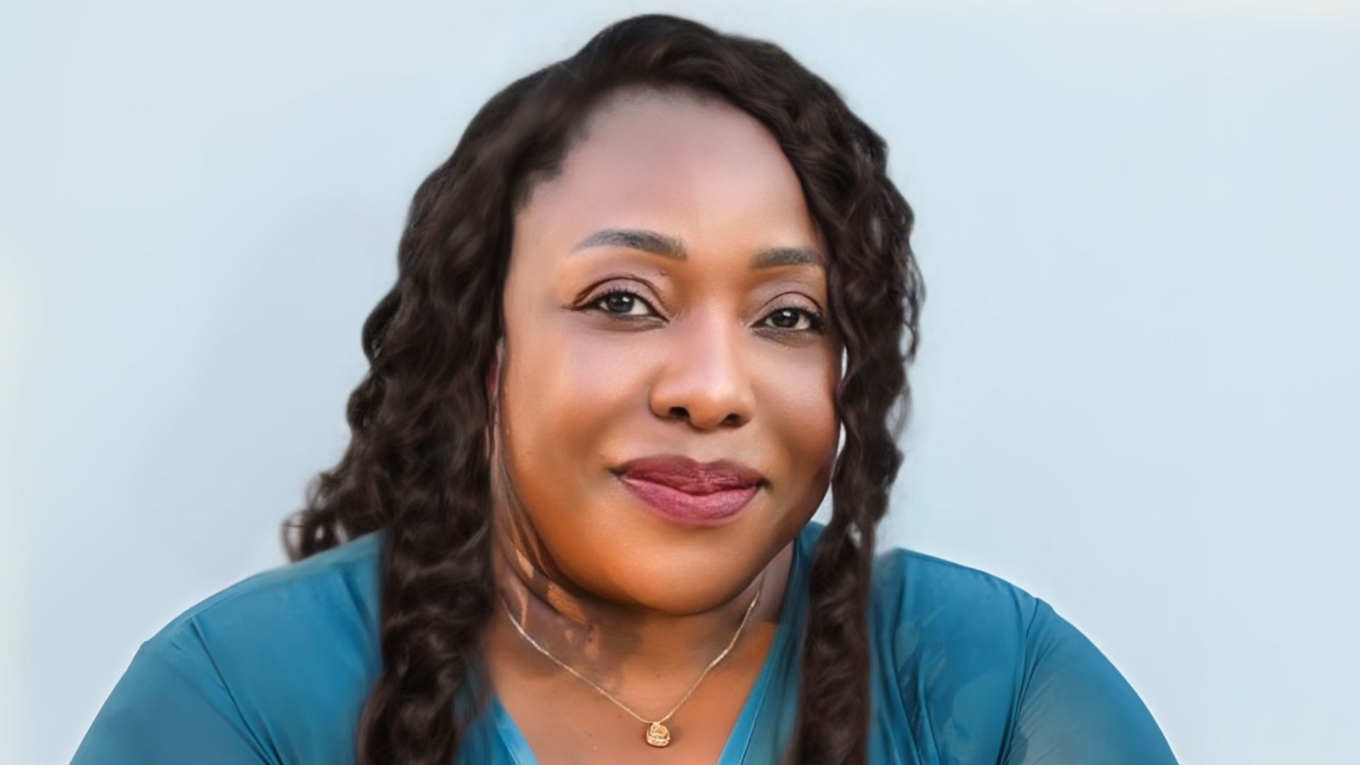 Head and shoulders photo of Lydia L Balogun-Wilson, set against light blue-grey background