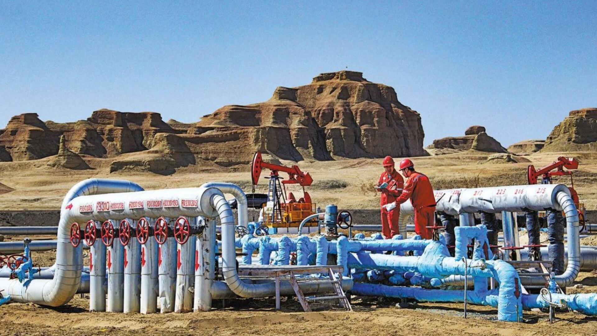 Workers checking equipment at oil field