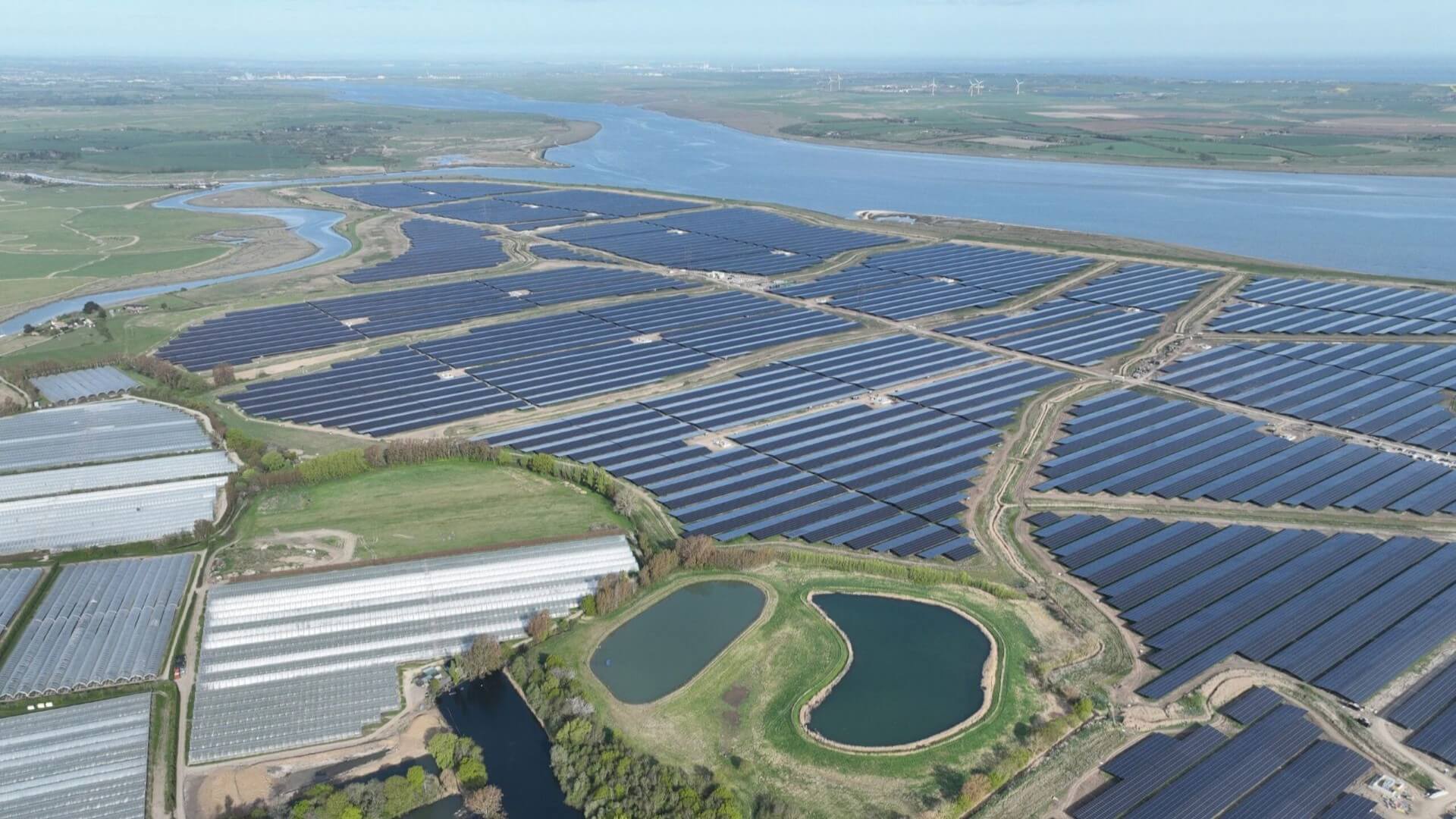 Aerial view of large solar farm next to a river
