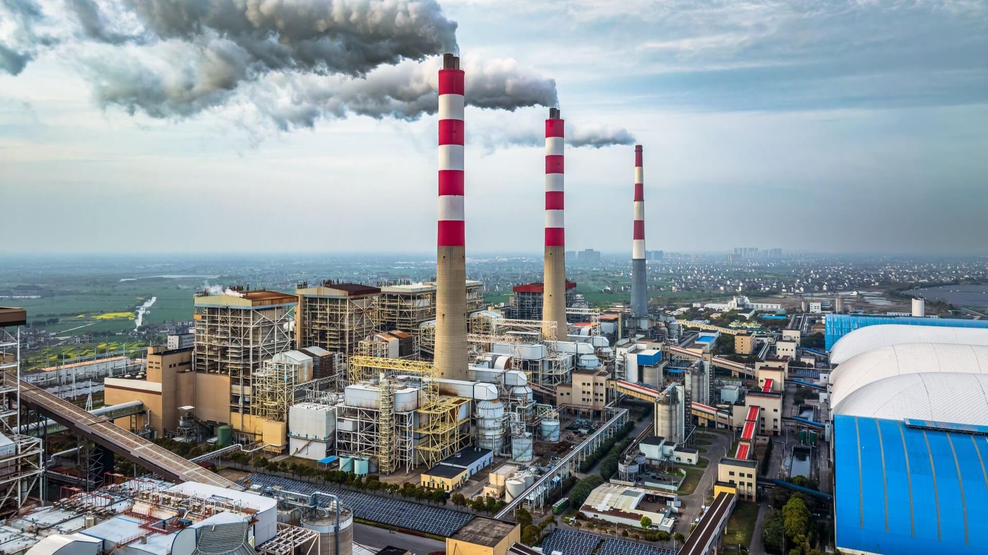 Coal power plant with three smoking chimneys