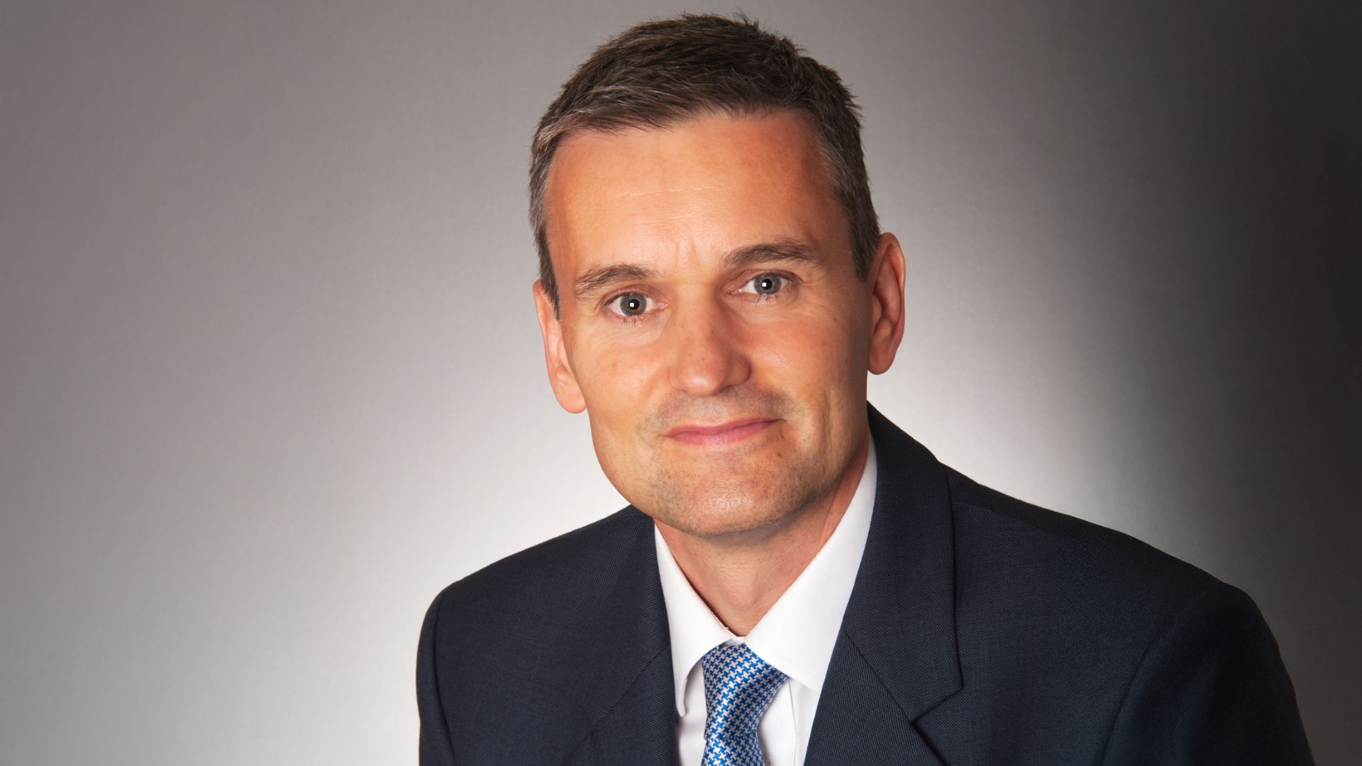 Head and shoulders photo of Simon Virley set against graded grey background
