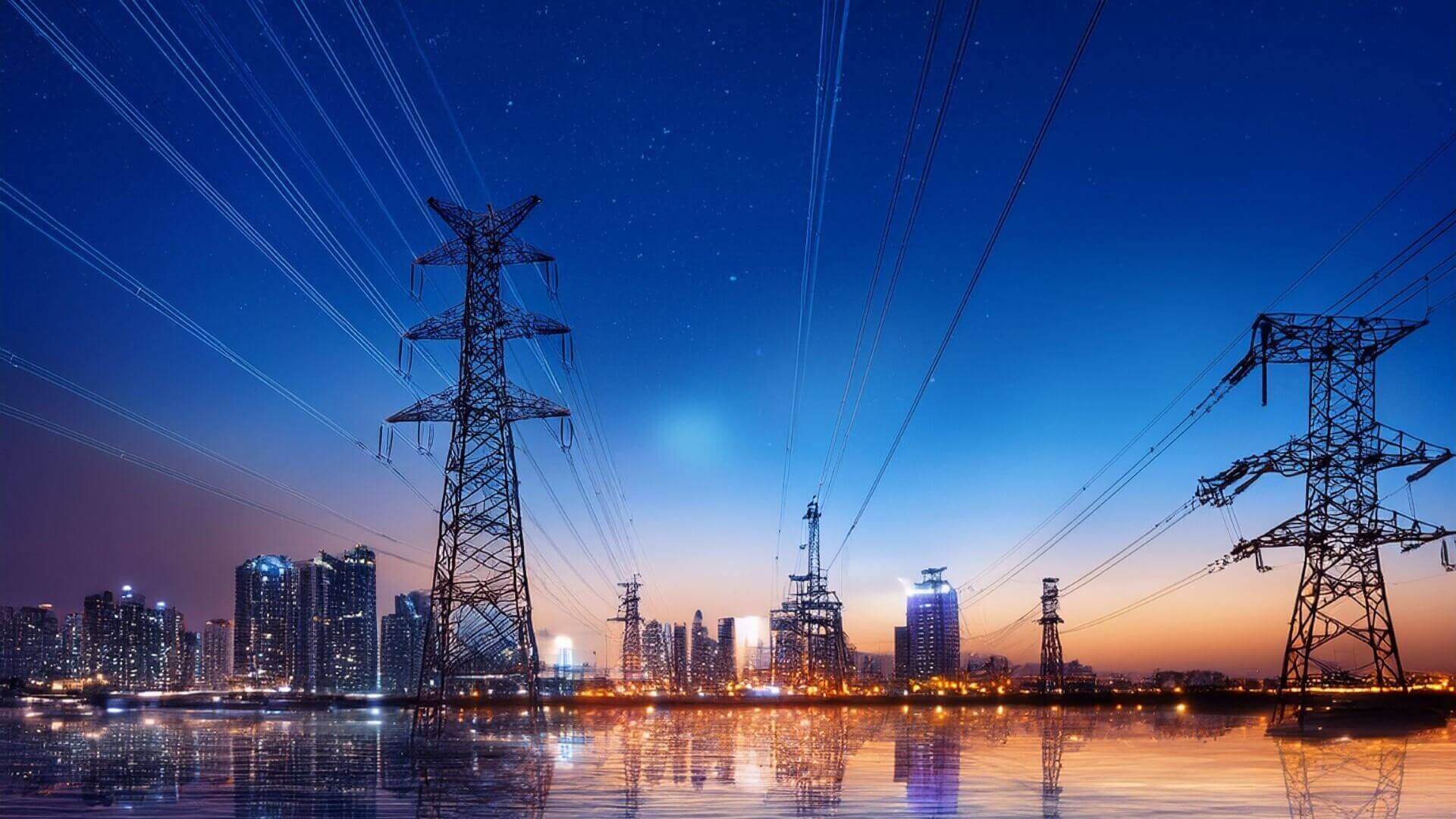 Lit up city skyline in background with two electricity pylons in foreground