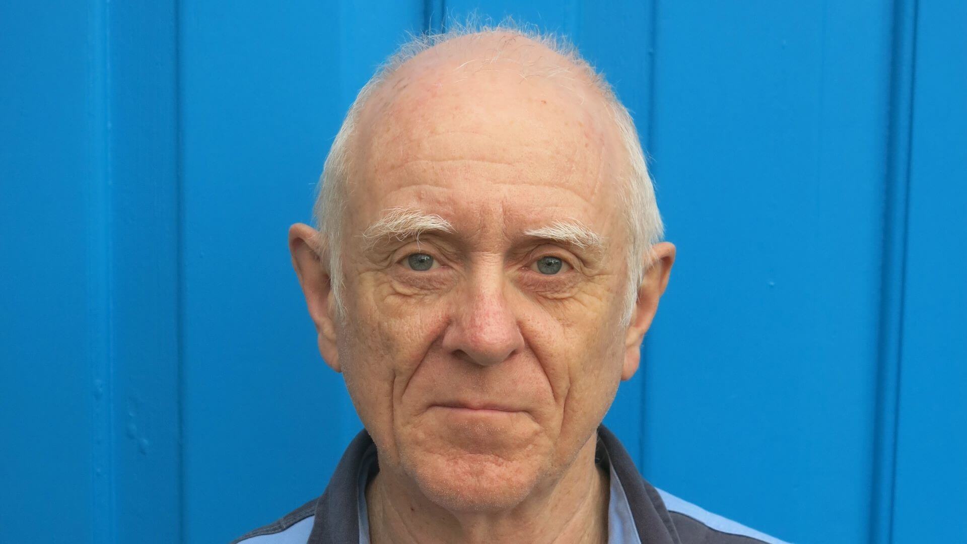 Head and shoulders photo of Steve Hodgson, standing in front of blue door