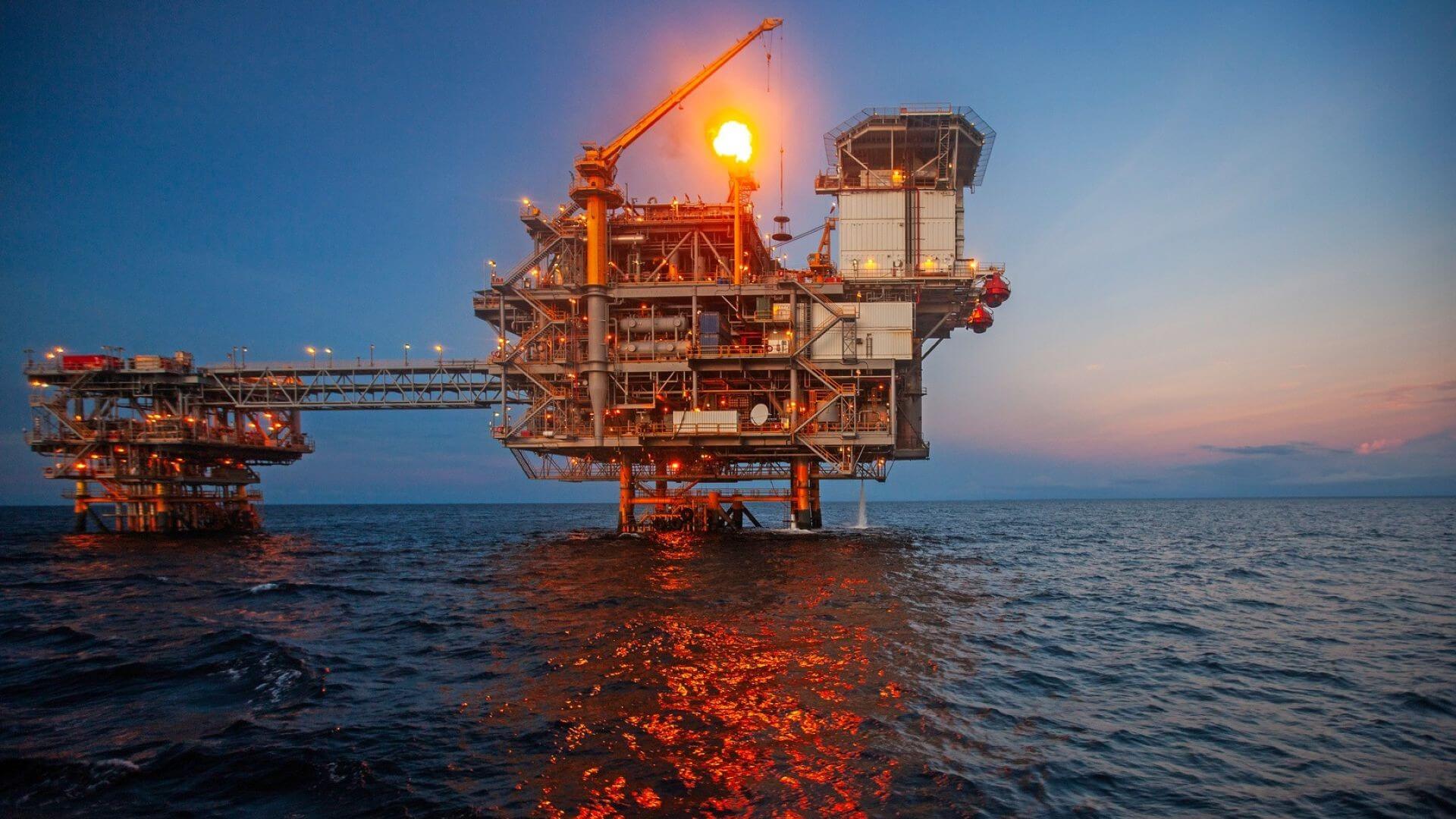 Offshore platform with gas flare at sunset