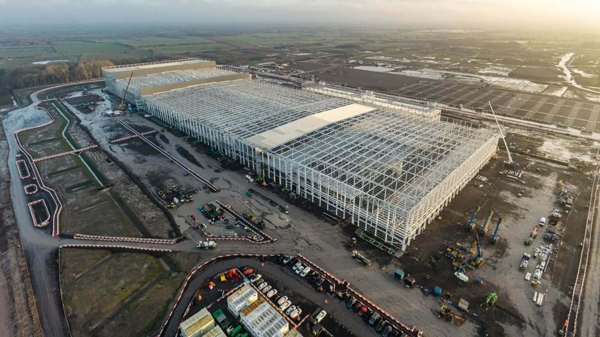 Aerial view over large industrial factory in the initial stages of construction, showing all steel framework in place