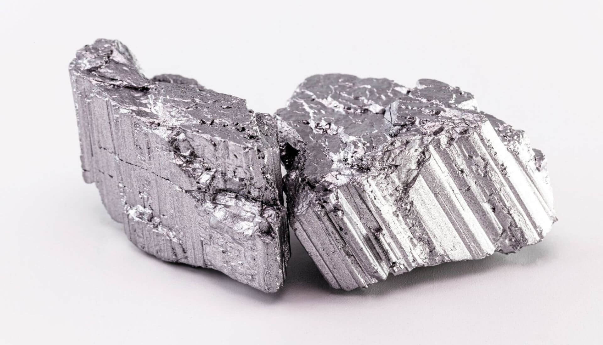 Close up view of two lumps of shiny grey material, with striations on side and lumpy on top