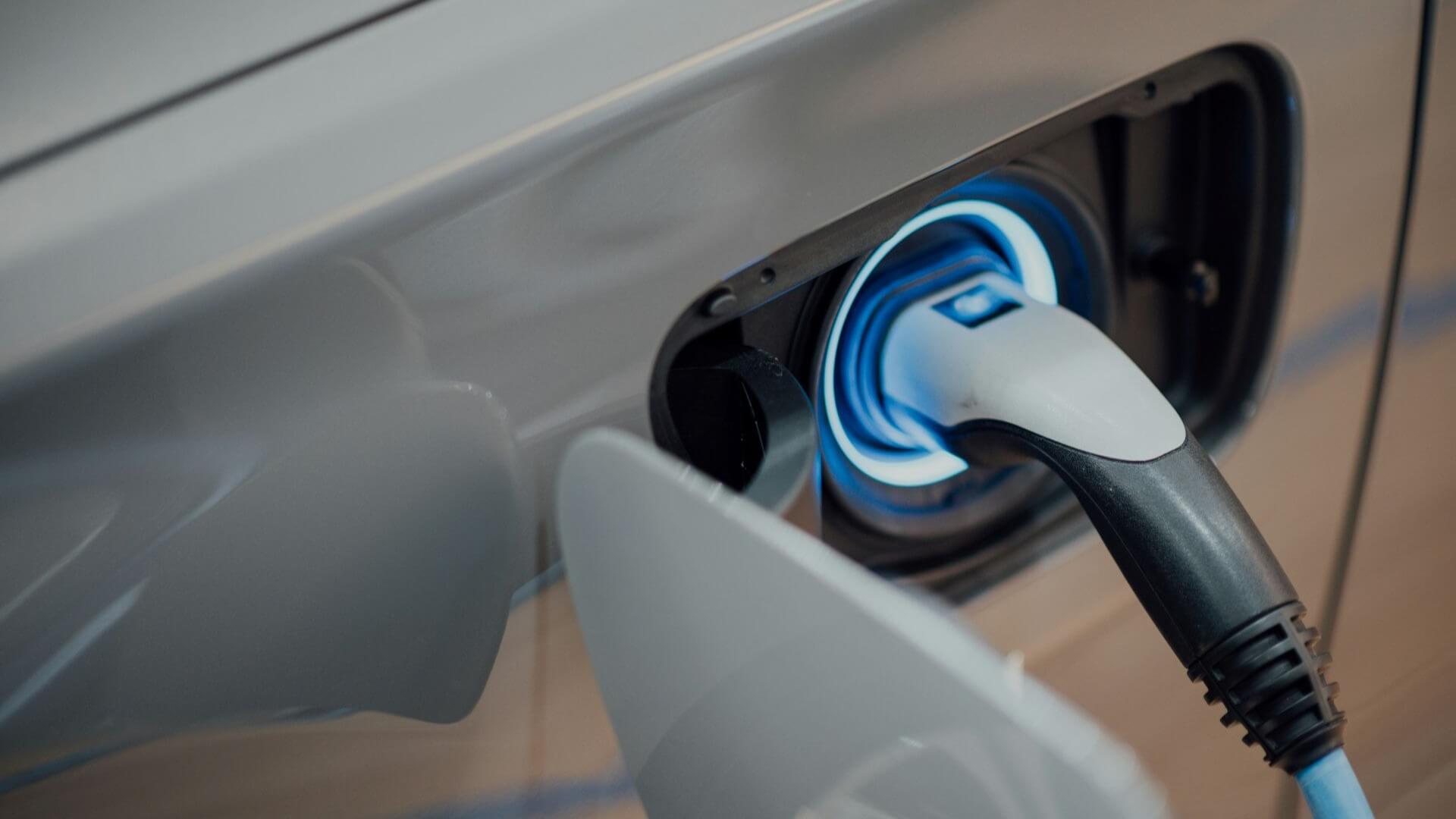Close up of electric charger plugged into electric vehicle