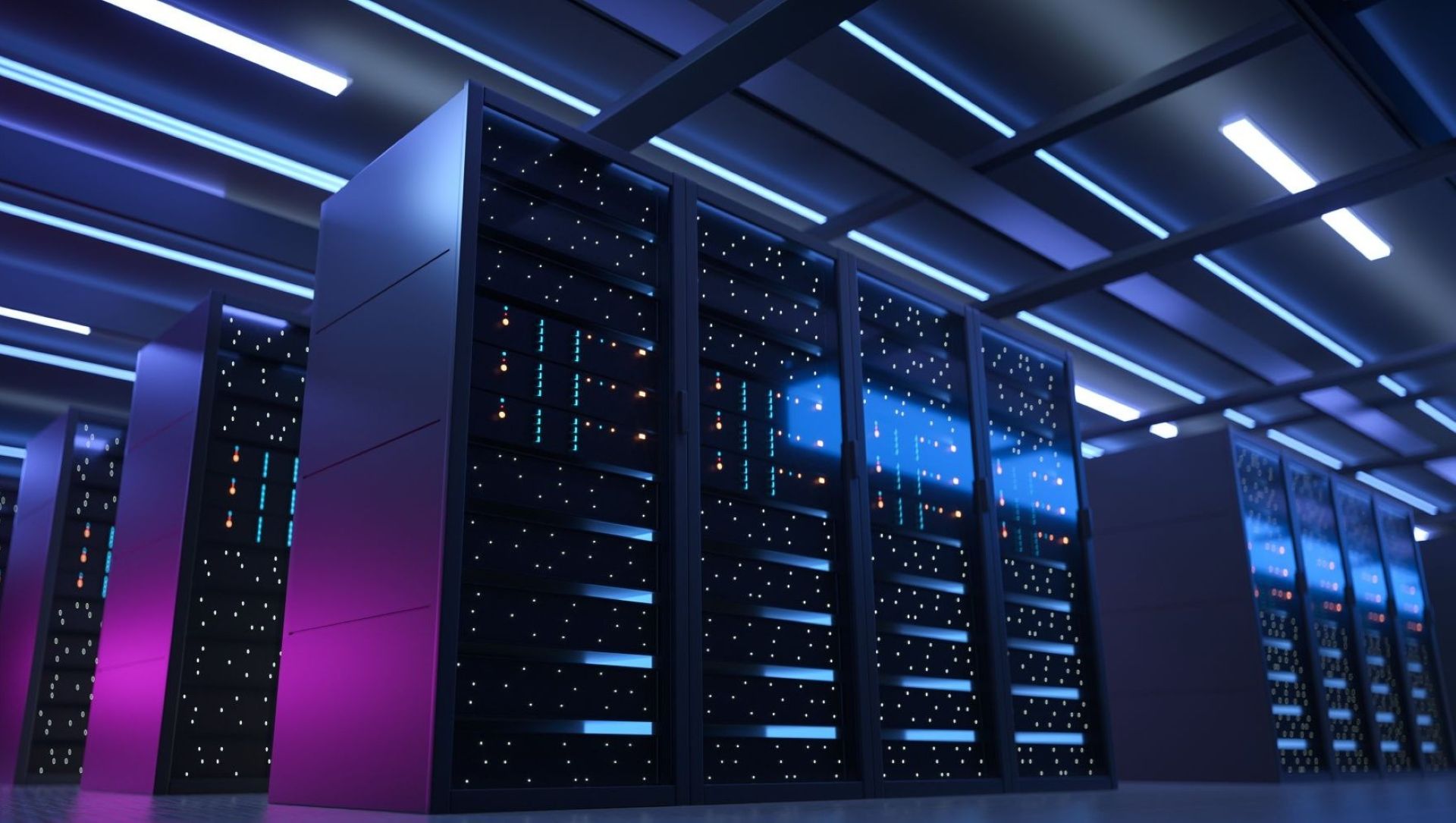 Rows of large, dark black mainframe computers with blue lights, lined up in darkened room