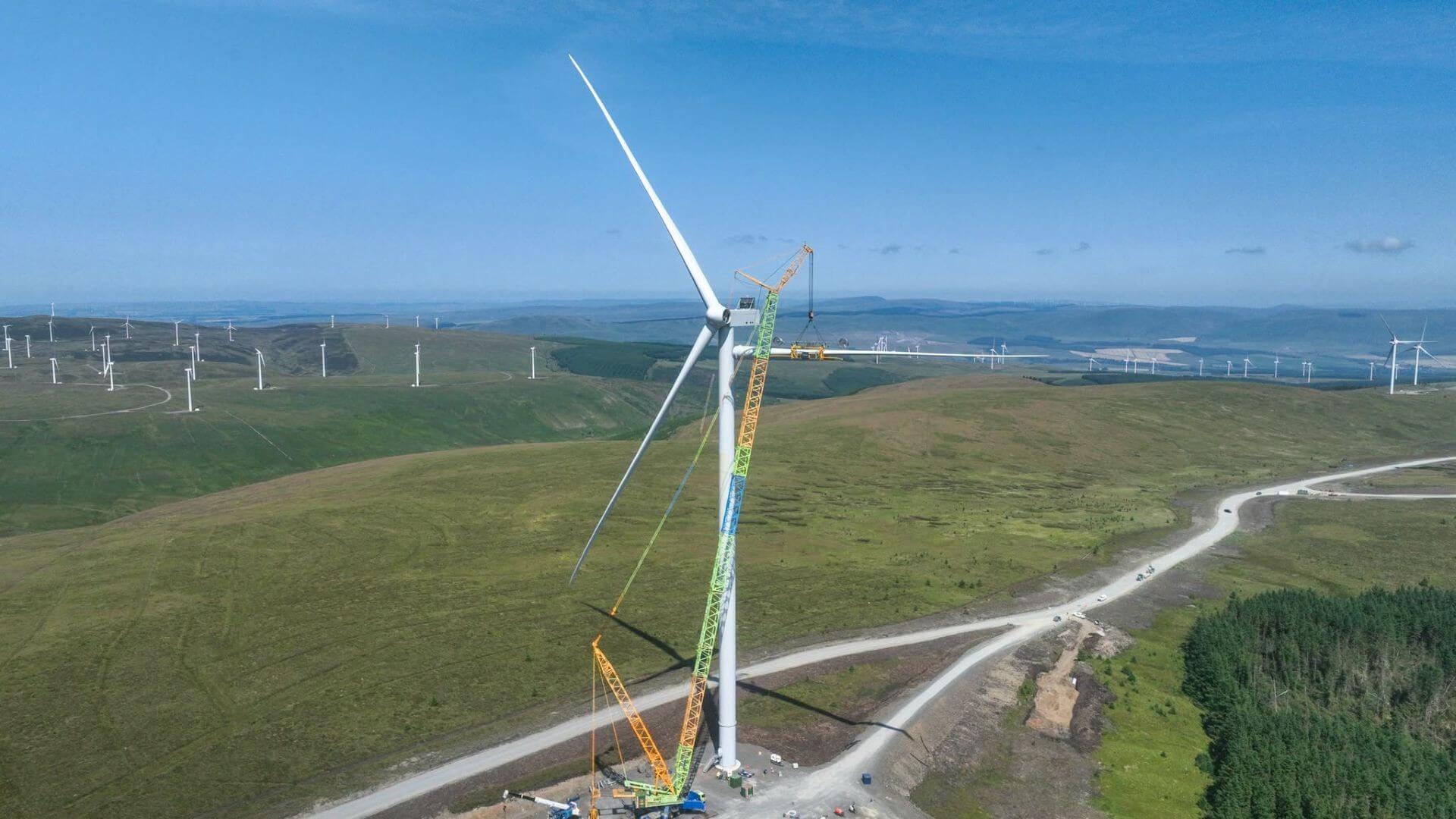 Crane and wind turbine on hill