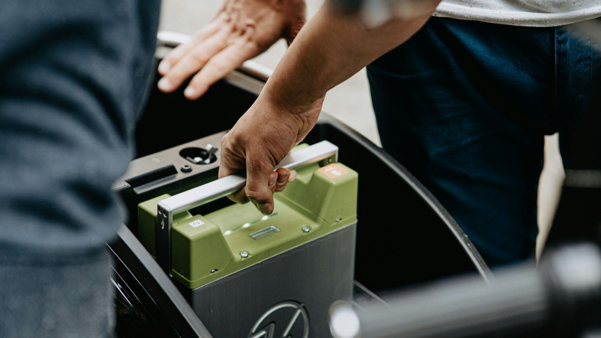 Close up of hand holding a battery for an electric scooter, to swap it out for another
