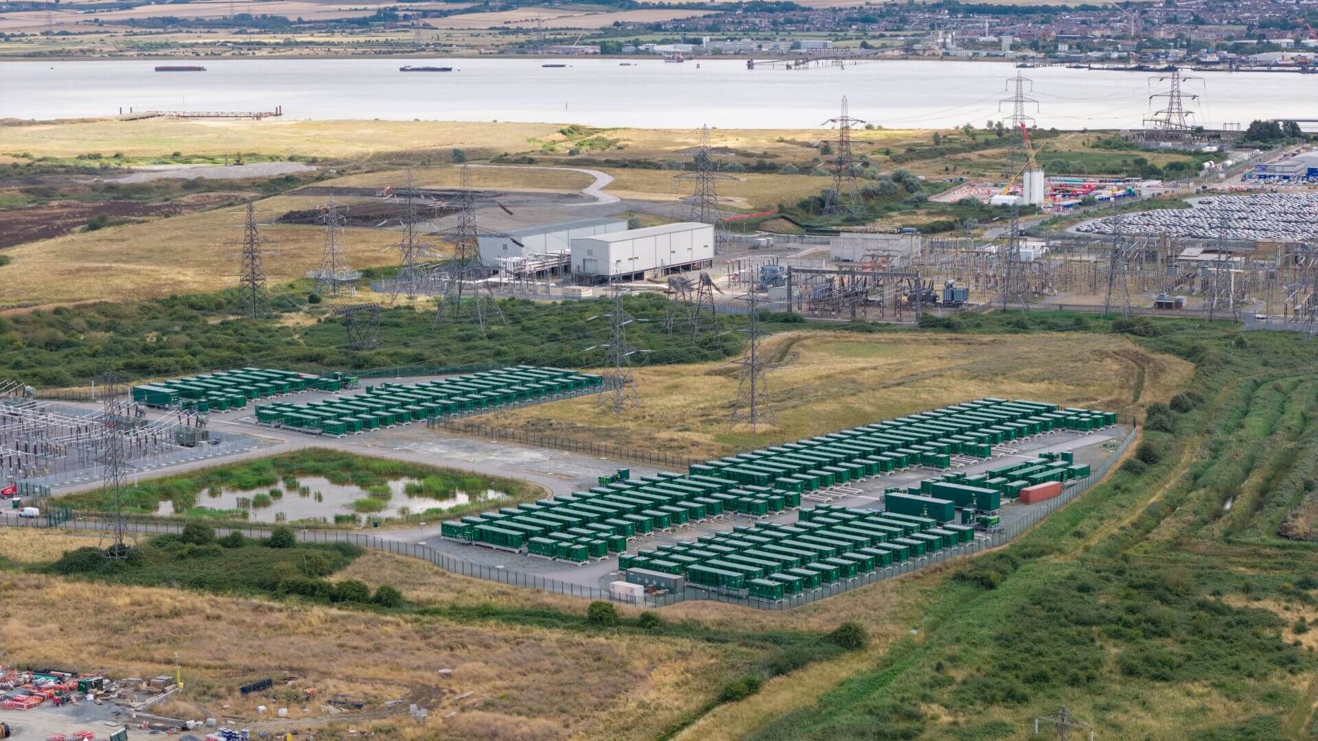Aerial view of battery energy storage facility near river