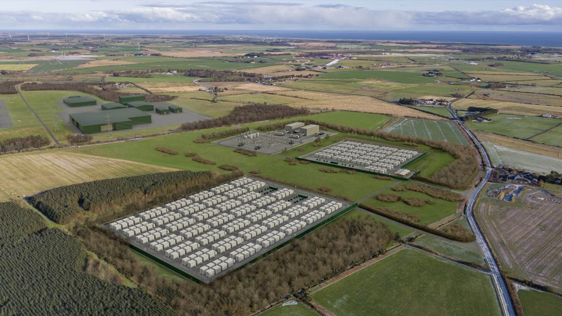 Aerial view of rows of battery energy storage system, set out in two square formations and surrounded by green fields and trees